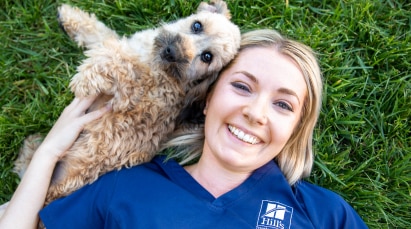 Hund und Tierpflegerin im Gras