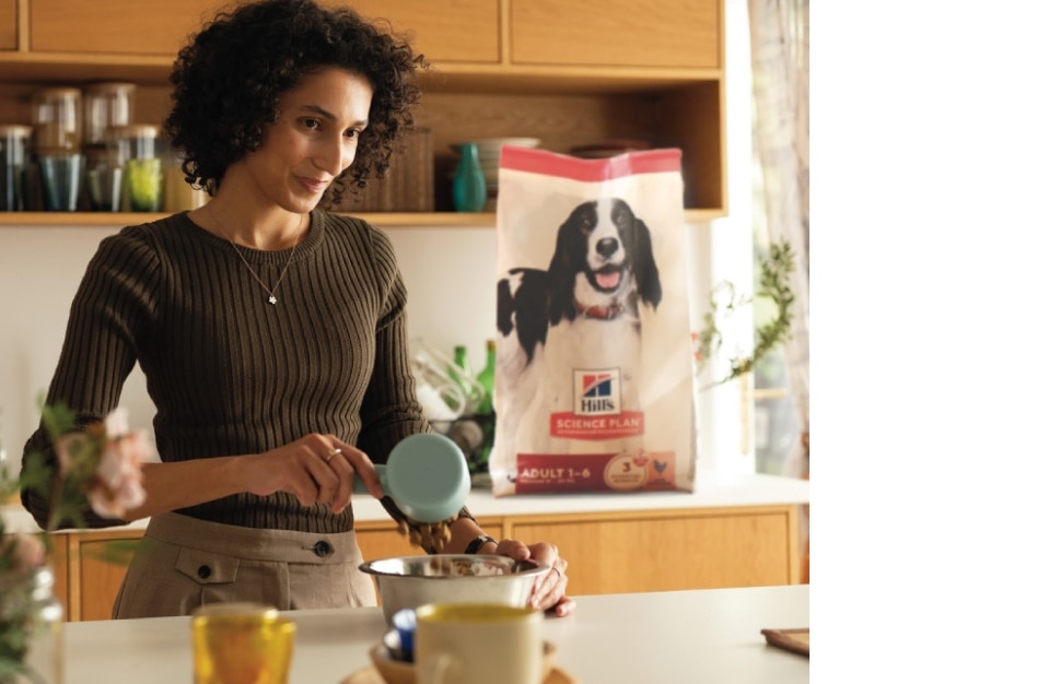 Eine Frau gibt Hill's Futter in einen Napf